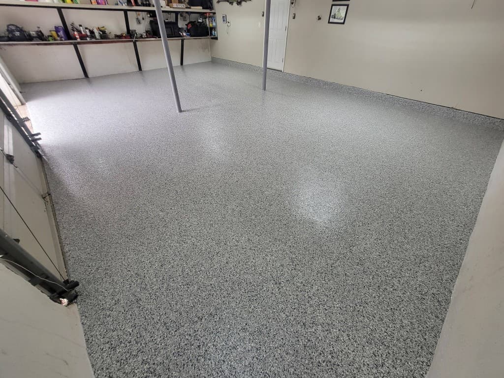 Same garage with full-broadcast gray flake epoxy and gloss topcoat after installation