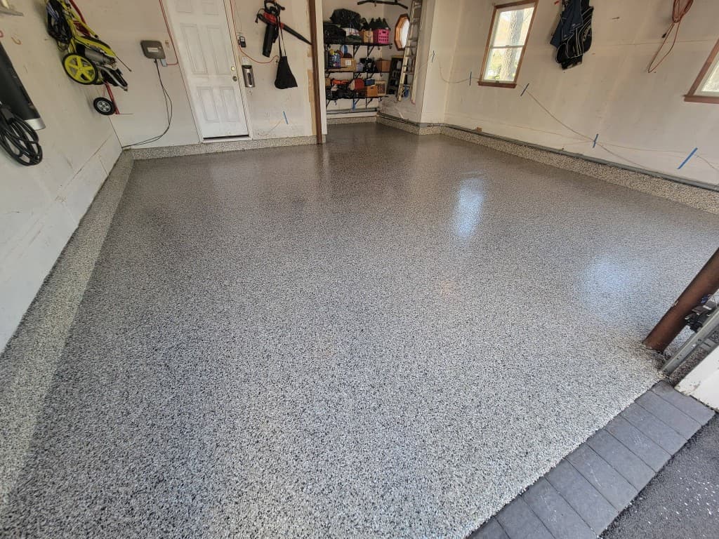 Same garage with full-broadcast gray flake epoxy and gloss topcoat after installation
