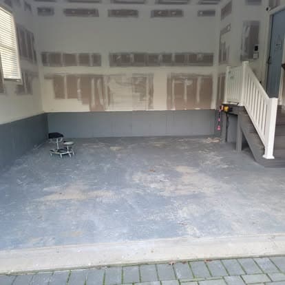 Garage floor with peeling old paint and bare concrete before metallic epoxy