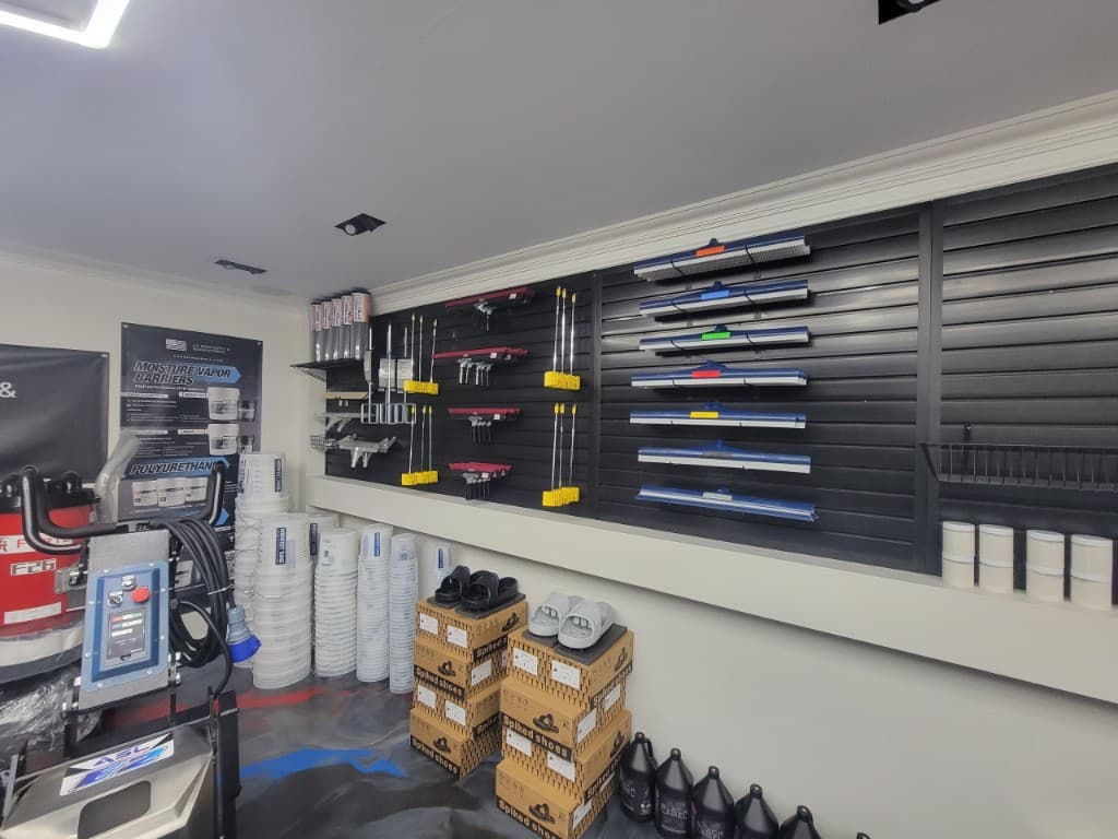 Epoxy application tools including squeegees, rollers, and spiked shoes on store wall